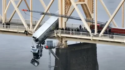 В Америці вантажівка ледь не впала з мосту в річку, але рятувальникам вдалось цього запобігти: відео - Auto24